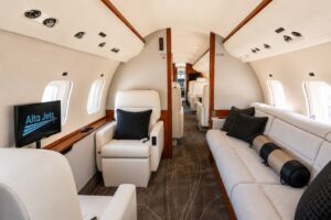 Private jet cabin with the Alta Jets logo on screen